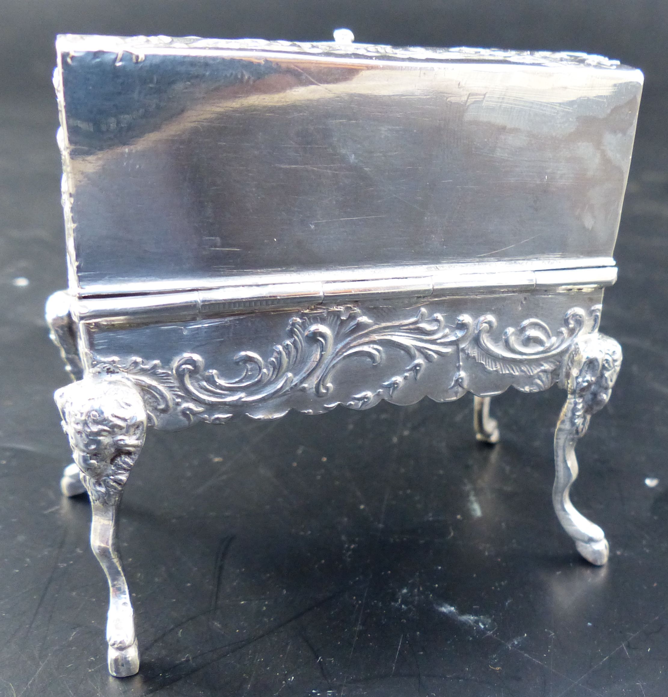 A Hanau embossed silver trinket box, formed as a miniature bureau on mask and hoof feet, width 2.5in,
